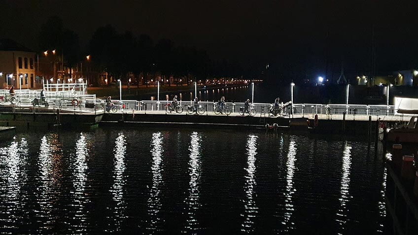 tijdelijke brug met verlichting over water